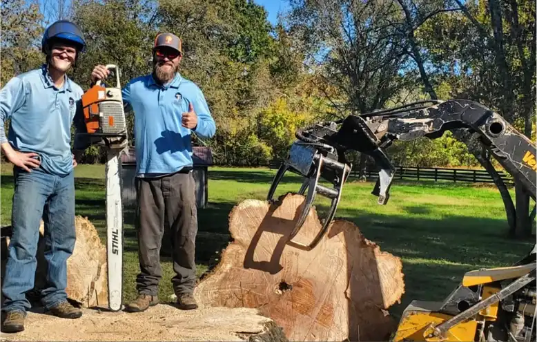 Land and Lot Clearing | TN Tree Preservation 19 Owner and employee of TN Tree Preservation holding chainsaw